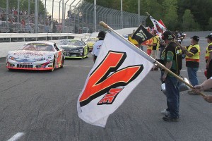 Cars parade at Airborne Speedway in front of their battle flags preceding an American Canadian Tour event this spring.  VP Fuels has put up a $1,000 bonus to the car that can qualify on the pole of the ACT International 500 at the race track in July.  (Photo Credit: Leif Tillotson)